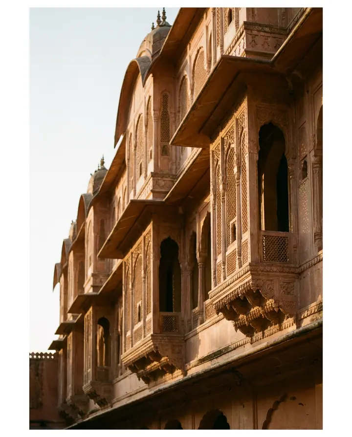 A pink sandstone palace facade in Jaipur at low sun.