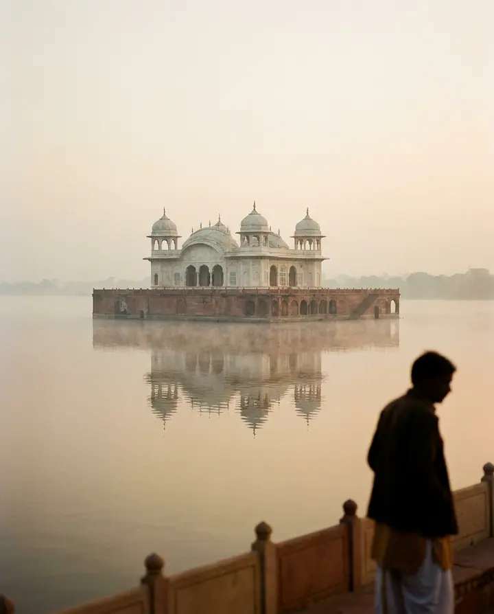 White marble palace rising from still lake water in Udaipur.